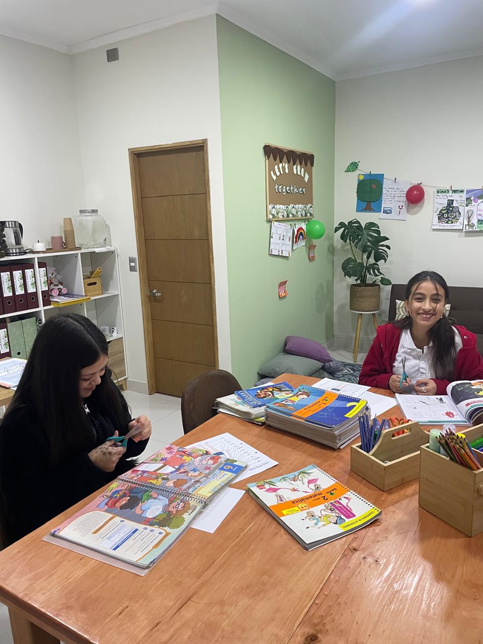 Estudiantes trabajando con material de inglés en una mesa de The English Lab